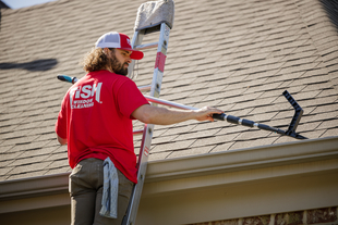 window cleaner cleaning gutters of a house