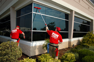 Two Cleaners Cleaning the Exterior Windows of a Business