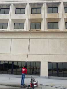 window cleaner cleaning high-up windows of building