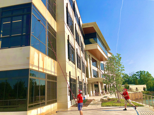 Two FISH Window Cleaners Using Water-Fed Poles to Clean Windows of 3-Story Commercial Building
