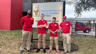 four fish window cleaners standing in front of 'Ronald McDonald House Charities' sign