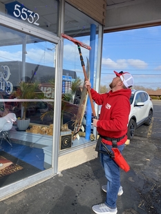 window cleaner cleaning windows of a small coffee shop