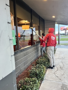 two window cleaners cleaning windows of building
