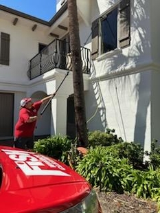 window cleaner cleaning windows of a house with a pole