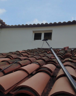 long pole cleaning the window of a house
