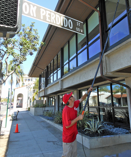 window cleaner cleaning windows of a building with a pole