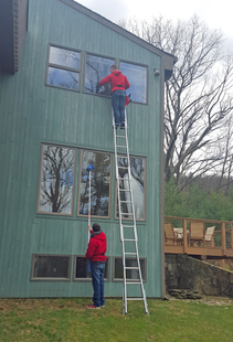 window cleaners cleaning windows of tall house