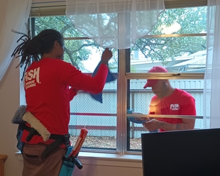 one window cleaner cleaning the interior window while another cleaner is cleaning the exterior window