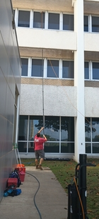 window cleaner cleaning hard-to-reach windows of a building