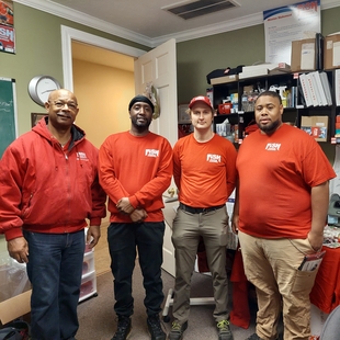 owner lori allen standing with some people that make up the fish team