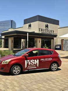 red fish window cleaning car parked in front of truluck's