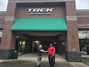window cleaner shaking hands with man in front of trek