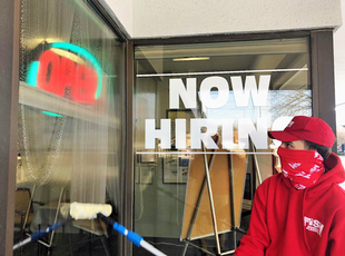 Image of Fish Window Cleaner Cleaning Window with Now Hiring Signage