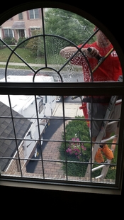 window cleaner cleaning semi-circle window of a house