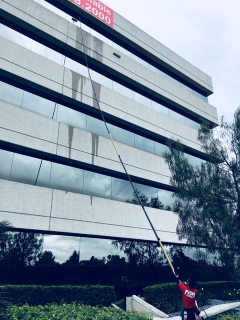 Image of Window Cleaner Cleaning 5 Story Building with a Water-Fed Pole