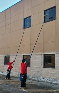 Two Fish Window Cleaners Using Poles to Clean High Windows