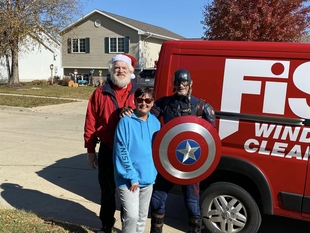 owner's curt and laurie mccallum standing with captain america in front of a red fish window cleaning van