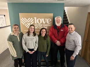 owner curt mccallum posing with three women and a man at cedar valley gearheads ministries