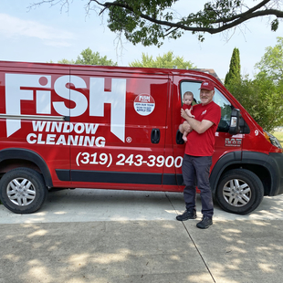 Image of Owner Curt McCallum with Baby Standing in Front of FISH Van