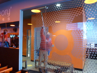 Image of FISH Window Cleaner Cleaning Windows for Orange Theory Fitness