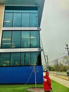 Image of FISH Window Cleaner Using Water-Fed Pole to Clean 3-Story Building