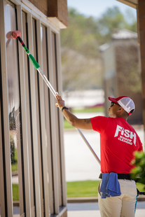Image of Fish Window Cleaner Cleaning Storefront Windows with Squeegee and Pole
