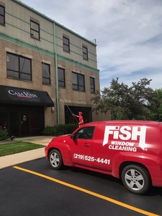 Fish Window Cleaning Branded Vehicle and Cleaner Cleaning 3rd Story Windows with Pole