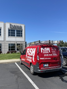 red fish window cleaning van parked in front of a building