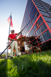 Image of Fish Window Cleaner Using Water-Fed Pole to Clean Building Windows