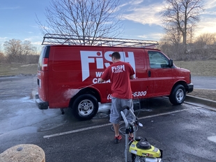 window cleaner cleaning red fish window cleaning van