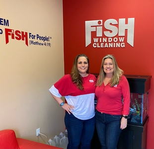Two Fish Window Cleaning Employees in Front of Red Wall with White Fish Window Cleaning Logo