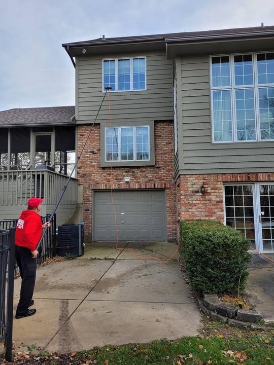 Two Branded Vans in Front of 2-Story House with Two Fish Window Cleaners on Porch
