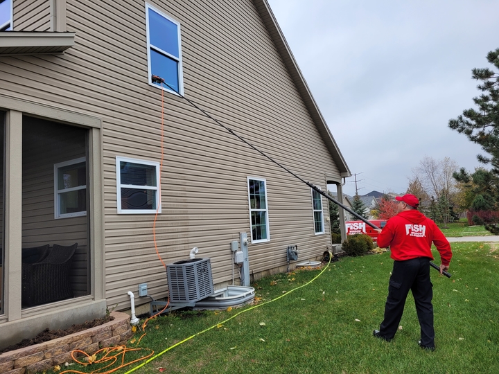 Window Cleaner Using Water-Fed Pole to Clean 2nd Story Windows Above Garage