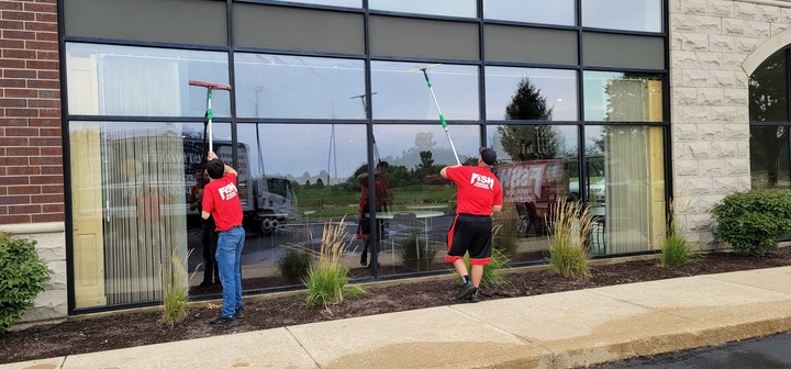 two window cleaners cleaning windows of a building