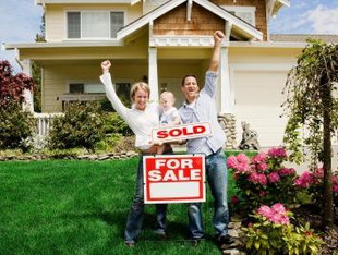 Family with Home and Sold Sign