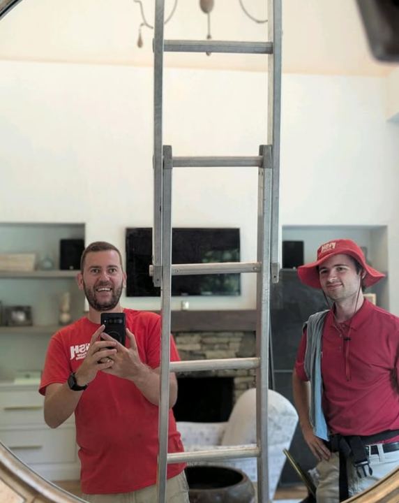 two window cleaners taking a mirror selfie together
