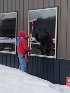 Fish Window Cleaner Cleaning Osso Restaurant Window with a Mop and Pole