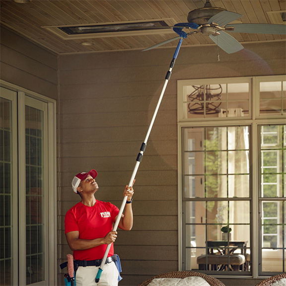 Fish Window Cleaning personnel cleaning ceiling fan.