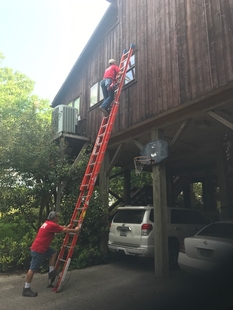 window cleaning cleaning window of a house while on a ladder