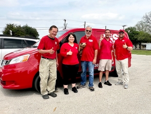 five fish window cleaning employees standing in front of a red fish van
