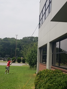 window cleaner cleaning windows of tall building