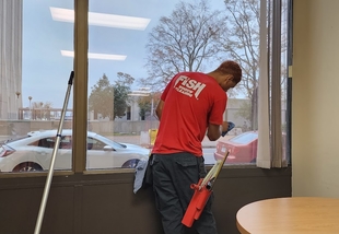 window cleaner cleaning interior side of windows of building