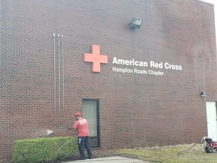 window cleaner powerwashing side of a building