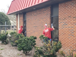 two window cleaners cleaning exterior windows of a building