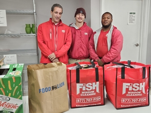 three fish window cleaning employees standing in front of bags of food