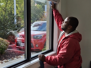 window cleaner cleaning a window indoors