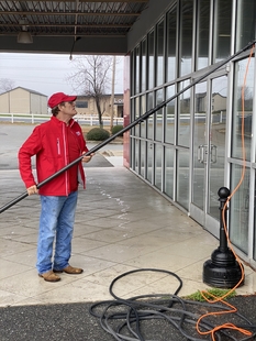 Window Cleaner Using Pole to Clean Exterior Windows of Animal Hospital