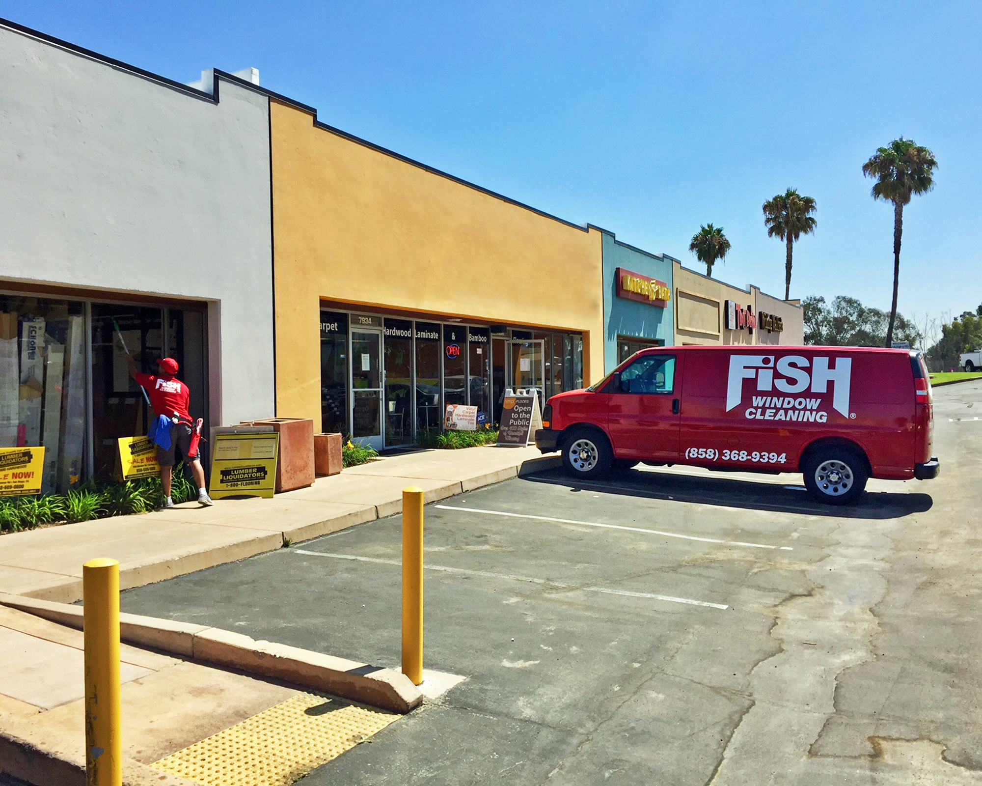 Fish Window Cleaning Branded Van in Front of Commercial Storefronts