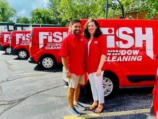 Owners, John and Sara English, in Front of 4 Branded Vans