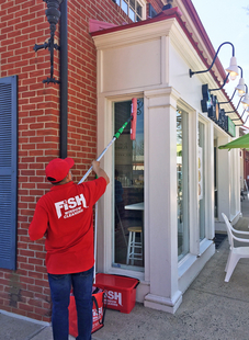 Fish Window Cleaner Cleaning Exterior Windows of Local Restaurant